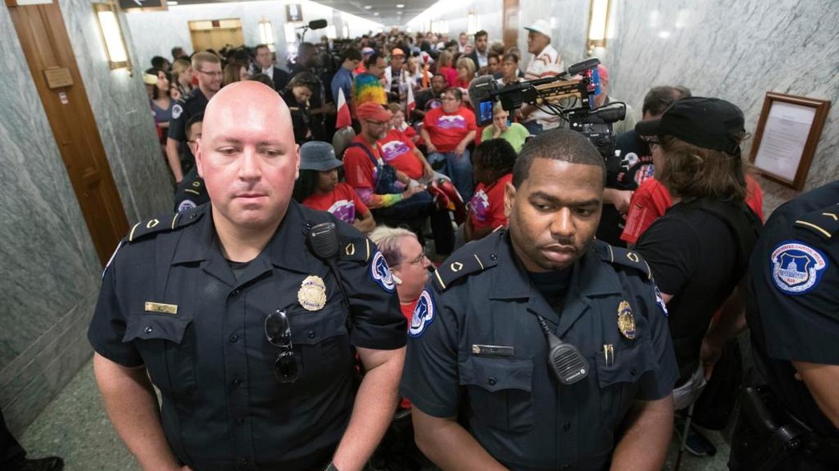 U.S. Capitol Police maintain order as hundreds of people, many with disabilities, arrive for a Senate Finance Committee hearing on the last-ditch GOP push to overhaul the nation's health care system, on Capitol Hill in Washington Monday.