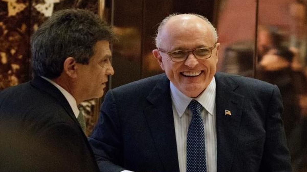 Former New York Mayor Rudy Giuliani, center, smiled as he left Trump Tower Friday. He’s proud of his work on behalf of the Iranian exile group, Mujahedin-e Khalq.