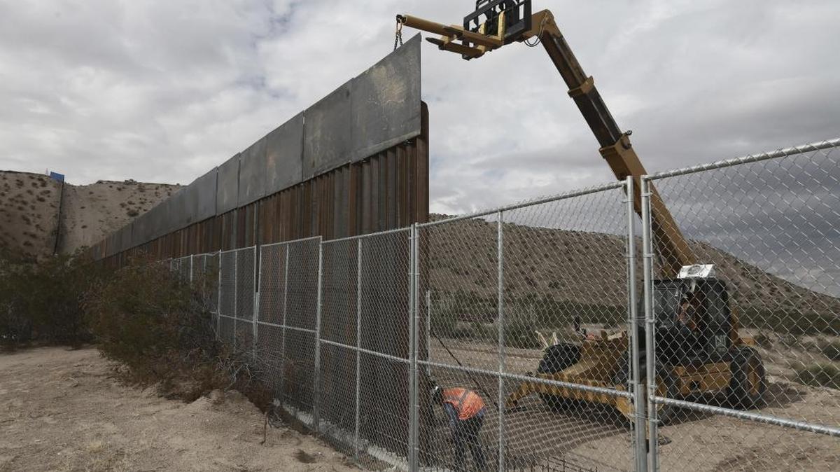 Workers raising a taller fence along the border separating the towns of Anapra, Mexico, and Sunland Park, New Mexico.