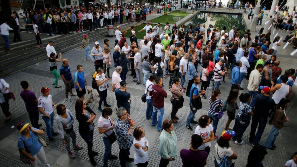 People line up to cast their ballots at poll station during a symbolic referendum in Caracas, Venezuela, on Sunday. Venezuela's opposition called for a massive turnout Sunday in a symbolic rejection of President Nicolas Maduro's plan to rewrite the constitution, a proposal that's escalating tensions in a nation stricken by widespread shortages and more than 100 days of anti-government protests.