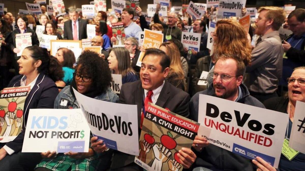 Sergio Martinez, center, a teacher at Sparks Elementary School in La Puente, Calif., joins hundreds of others as California educators voice their opposition to President Donald Trump's nomination of Besty DeVos as secretary of education, at a California Teachers Association meeting in Los Angeles on Saturday, Jan. 28, 2017.