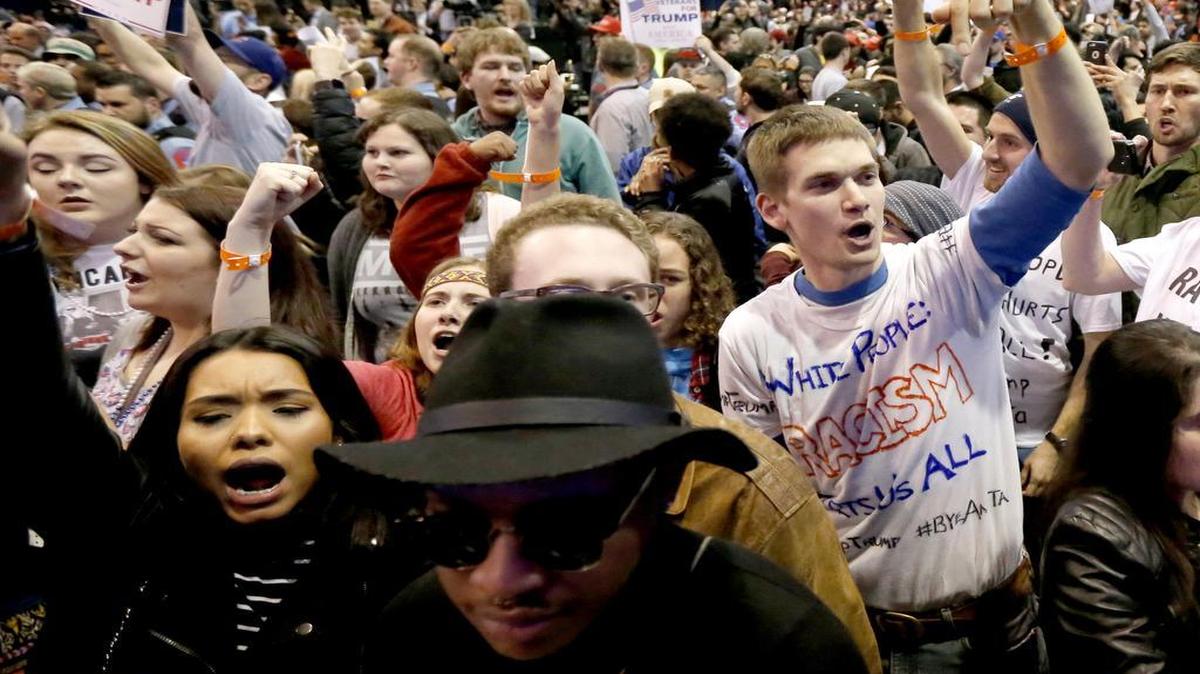 In this Friday, March 11, 2016, photo, protesters of Donald Trump, right, chant after a rally on the campus of the University of Illinois-Chicago was canceled due to security concerns in Chicago.