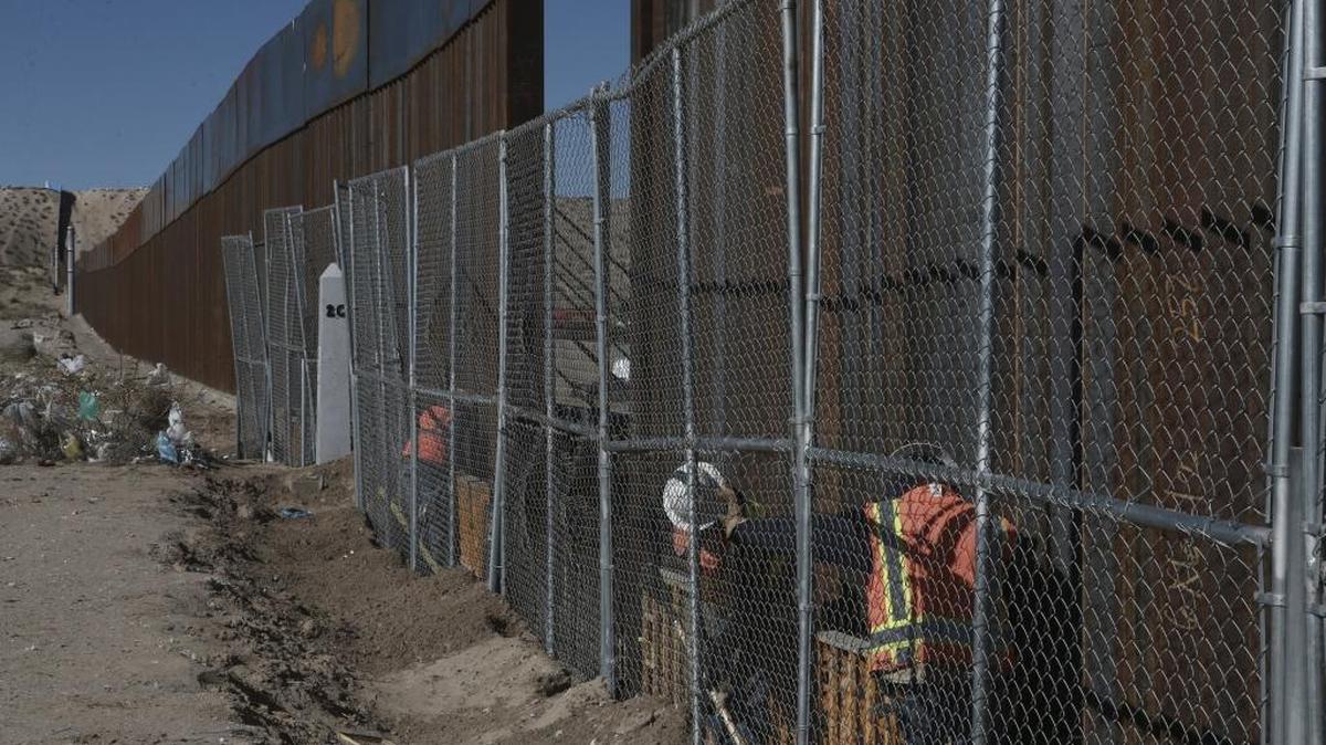 Workers raise a taller fence on the Mexico-US border separating the towns of Anapra, Mexico and Sunland Park, N.M.