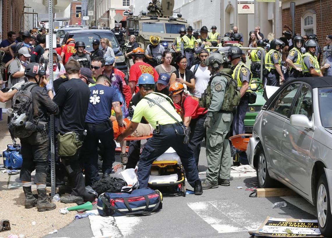 Rescue personnel help injured people after a car ran into a large group of protesters after an white nationalist rally in Charlottesville, Va., Saturday. The nationalists were holding the rally to protest plans by the city of Charlottesville to remove a statue of Confederate Gen. Robert E. Lee. There were several hundred protesters marching in a long line when the car drove into a group of them.