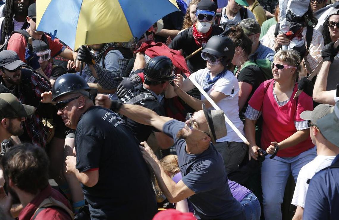White nationalist demonstrators clash with counter demonstrators at the entrance to Lee Park in Charlottesville, Va., Saturday, Aug. 12, 2017.