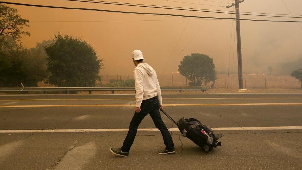 An area resident evacuates his Silverado Trail home as flames from a wildfire approach Monday, Oct. 9, 2017, in Napa, Calif.