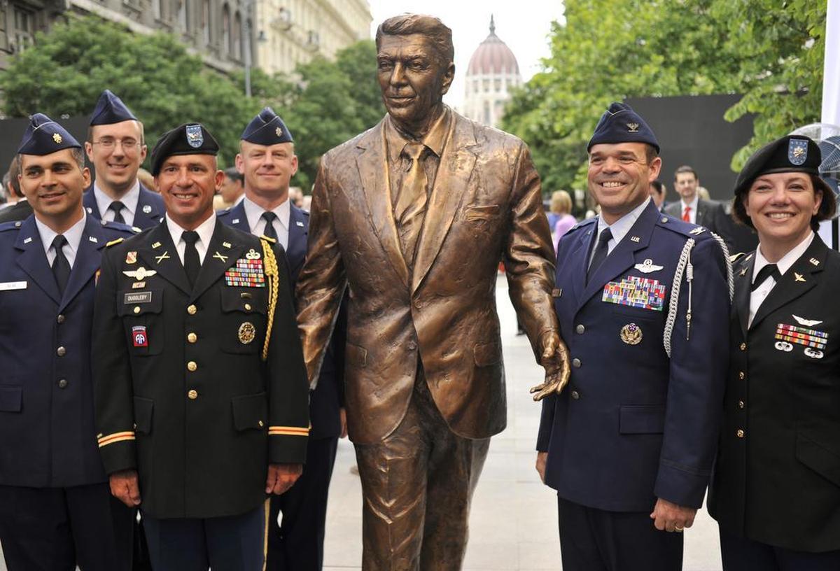 US Air Force and Army officers, serving in Hungary, pose with the new statue of late US President Ronald Reagan after a centennial commemoration in Budapest, Hungary, Wednesday, June 29, 2011.