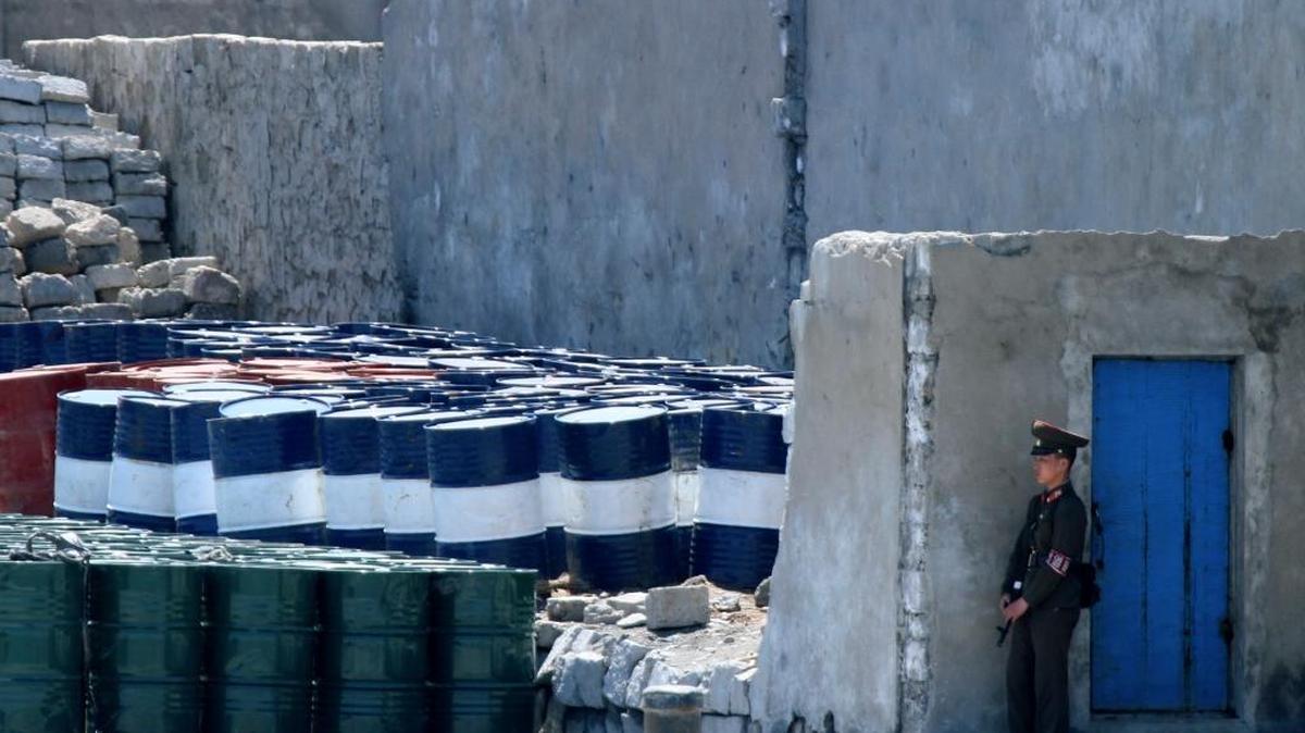 A North Korean soldier stands guard near oil barrels stocked up near the river bank of the North Korean town of Sinuiju, opposite the Chinese border city of Dandong. Chinese Vice Commerce Minister Qian Keming said on Monday the issue of China-U.S. trade should be kept separate from the issue of North Korean security threats, pushing back on statements from U.S. President Donald Trump.