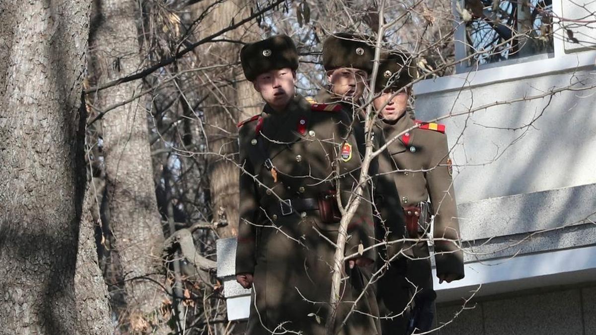 Three North Korean soldiers look at the South side near the spot where a North Korean soldier crossed the border on Nov. 13, at the Panmunjom in the Demilitarized Zone, South Korea.