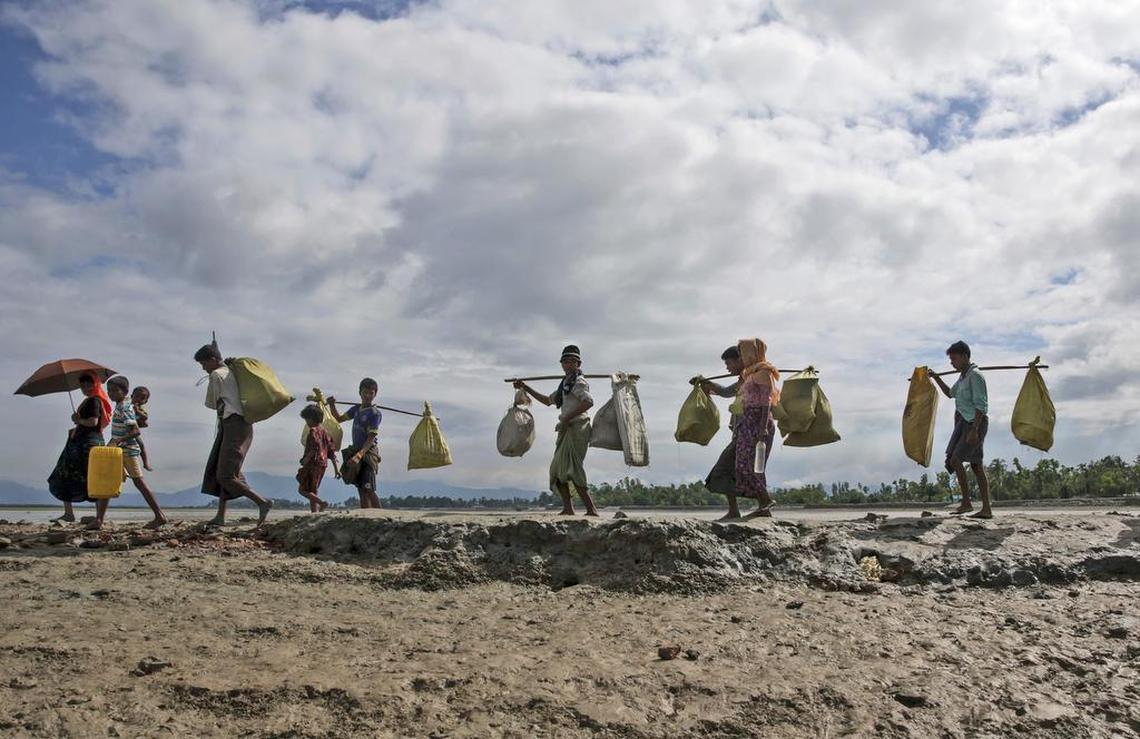 Rohingya Muslims, who crossed over from Myanmar into Bangladesh, walk towards a refugee camp in Shah Porir Dwip, Bangladesh, Thursday, Sept. 14, 2017. Nearly three weeks into a mass exodus of Rohingya fleeing violence in Myanmar, thousands were still flooding across the border Thursday in search of help and safety in teeming refugee settlements in Bangladesh.