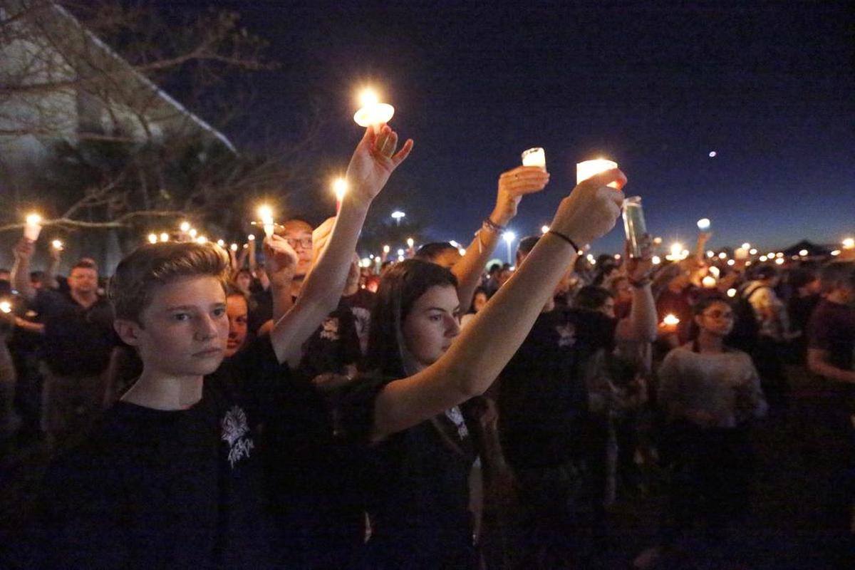 Attendees hold up their candles at a candlelight vigil for the victims of the shooting at Marjory Stoneman Douglas High School, Thursday, Feb. 15, 2018, in Parkland, Fla. Miami Herald columnist Leonard Pitts, Jr. asks, “How do you reason with the person who thinks nobody died at Parkland?”