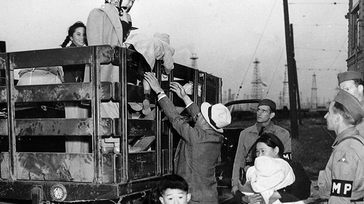 Japanese American citizens are loaded up in a truck for relocation in internment camps during World War II.