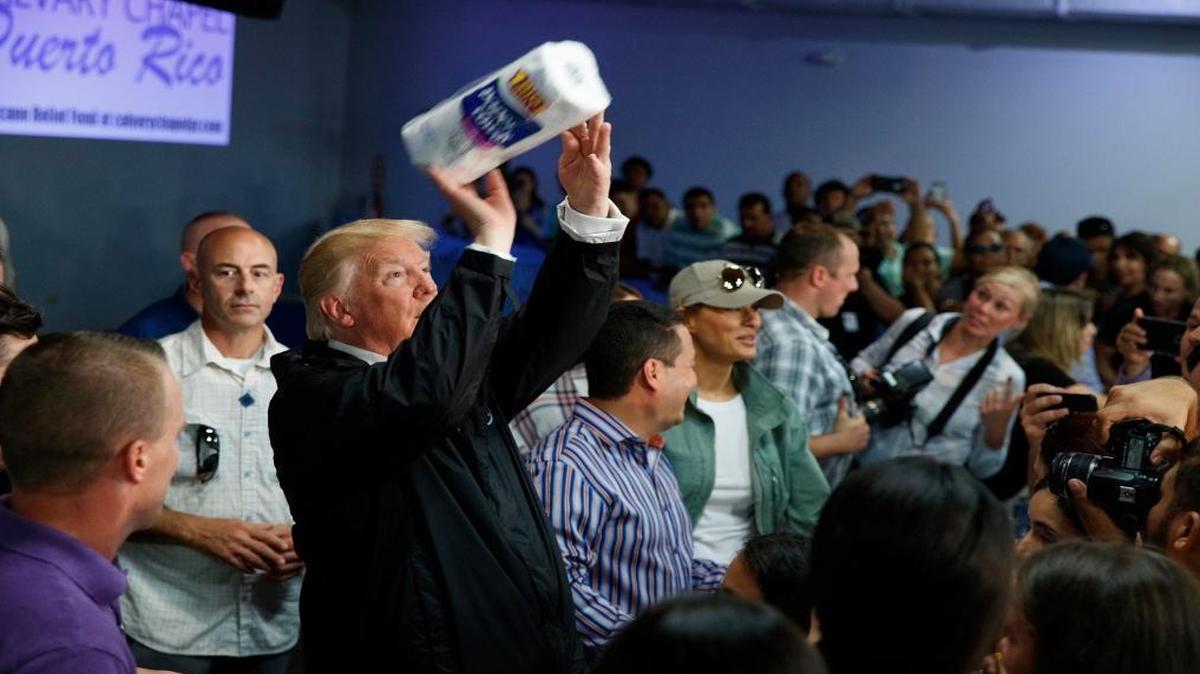 President Donald Trump tosses paper towels into a crowd as he hands out supplies at Calvary Chapel, Tuesday, Oct. 3, 2017, in Guaynabo, Puerto Rico. Trump is in Puerto Rico to survey hurricane damage.