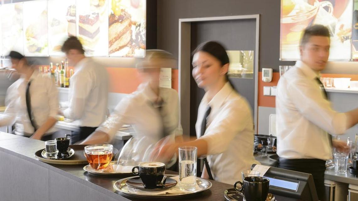 Busy waiter and waitresses working at bar night