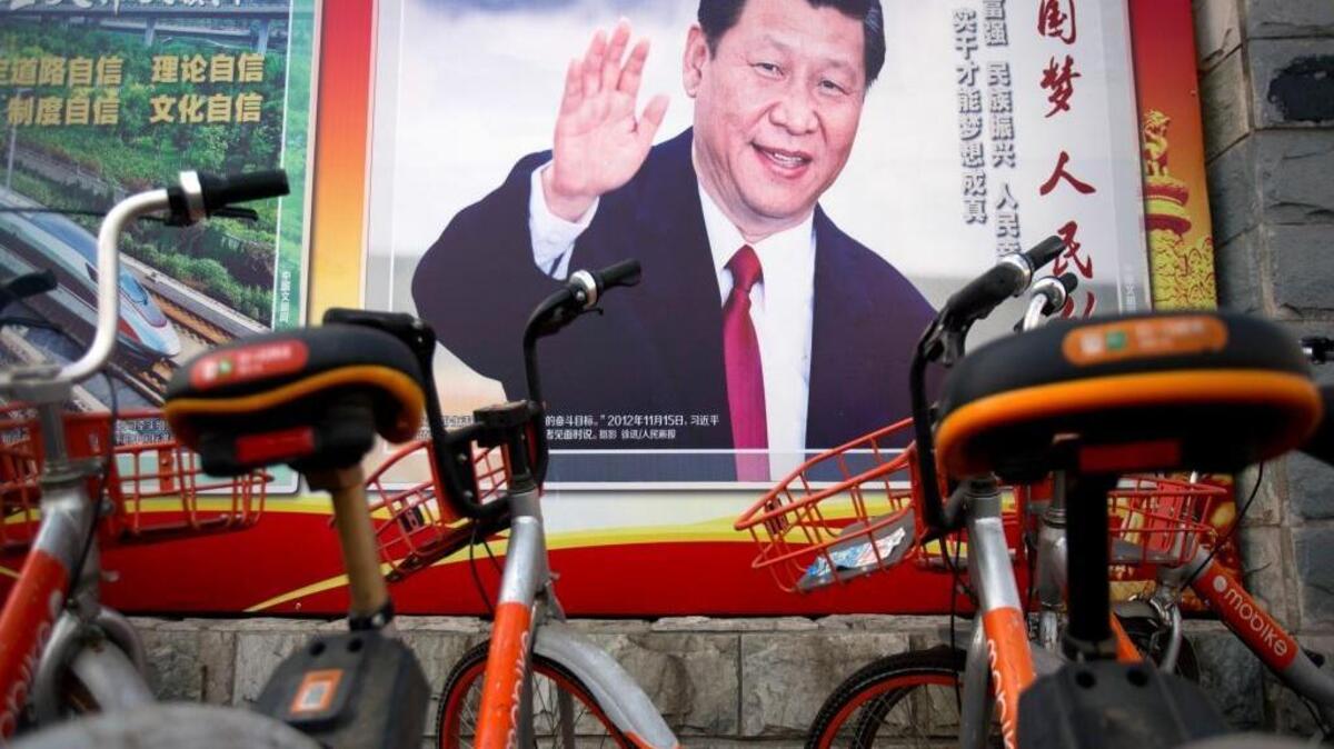 Shared bicycles are parked near a propaganda billboard showing Chinese President Xi Jinping along a street in Beijing, Friday, March 2, 2018. The annual meetings of China's top legislative bodies are set to begin on Saturday, during which the two-term limit on China's presidency is expected to be removed.