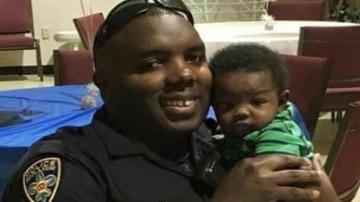 Montrell Jackson, holds his son, Mason, at a Father’s Day event for police officers in Baton Rouge, Louisiana.