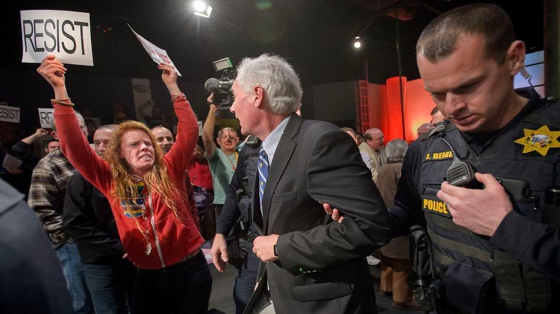 Rep. Tom McClintock, R-Elk Grove, center, is escorted by Roseville police through protesters outside Tower Theatre in Rosevillle on Saturday, Feb. 4, 2017. He held a town-hall meeting at the theater and hundreds of anti-Trump demonstrators chanted slogans and carried signs outside.