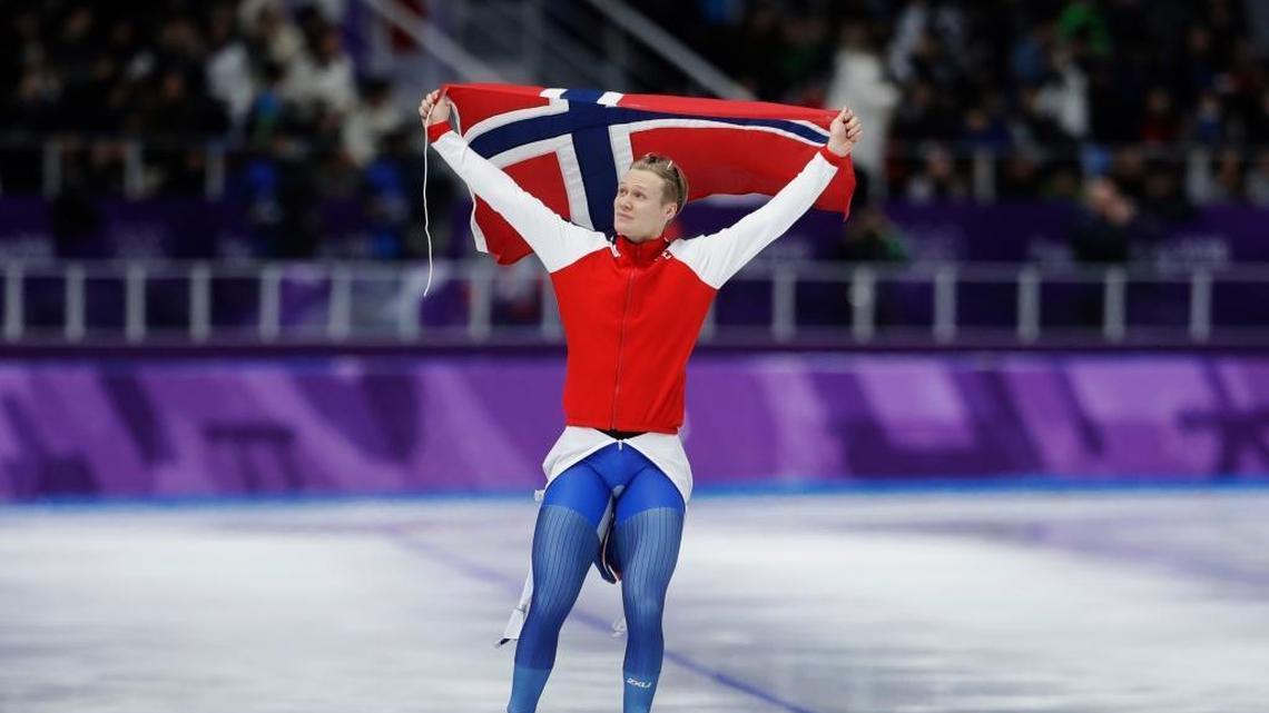 Gold medalist and new Olympic record holder Havard Lorentzen of Norway celebrates with the national flag after the men's 500 meters speedskating race at the Gangneung Oval at the 2018 Winter Olympics in Gangneung, South Korea, Monday, Feb. 19, 2018.