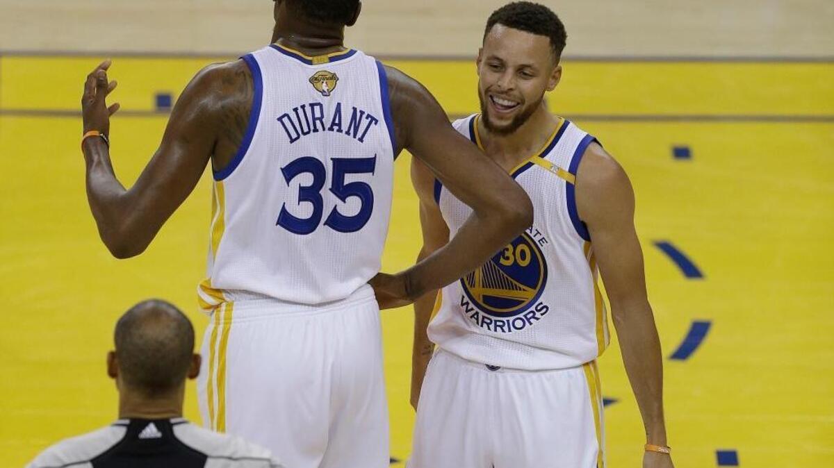 Golden State Warriors forward Kevin Durant (35) and guard Stephen Curry (30) react next to referee Dan Crawford during Game 1 of the NBA Finals against the Cleveland Cavaliers in Oakland on Thursday.