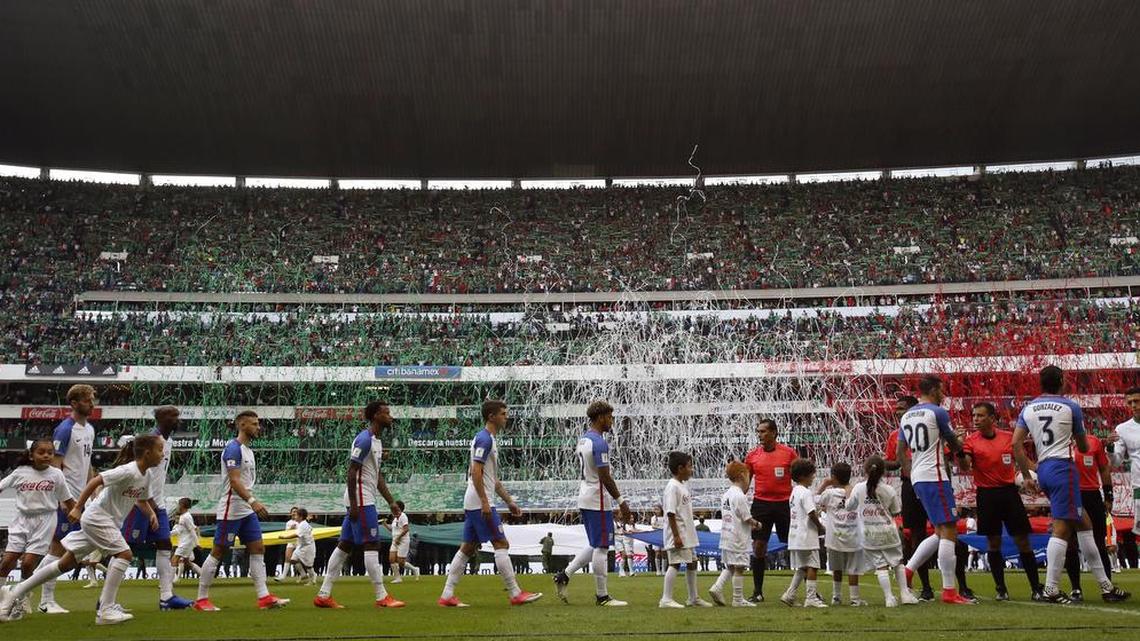 U.S. players enter the pitch as fans release confetti with the colors of the Mexican flag before their World Cup soccer qualifying match at Azteca Stadium between the U.S. and Mexico in Mexico City, Sunday, June 11, 2017.