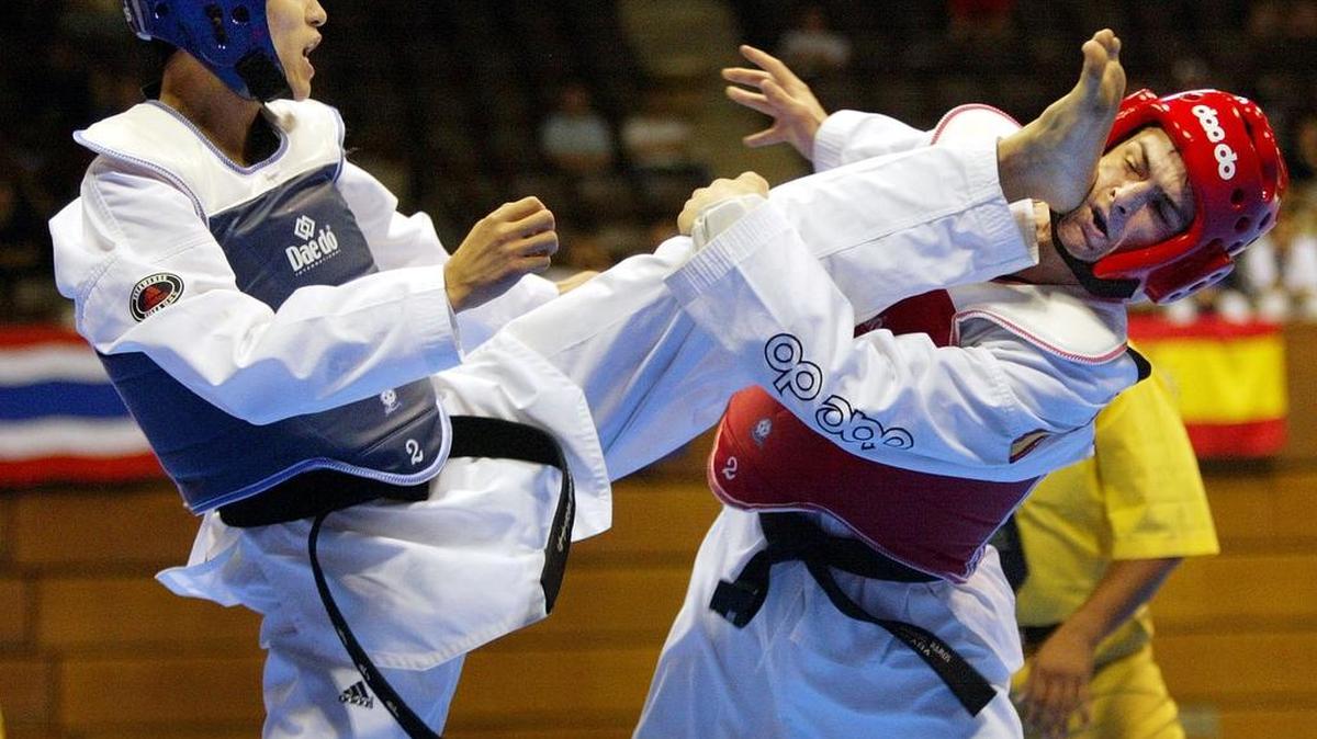 South Korea's Kim Jin-hee, left, kicks the face of Spain's Juan Ramos during the fin weight final of the World Cup Taekwondo 2002 in Tokyo Tuesday, July 16, 2002. Kim won the gold.