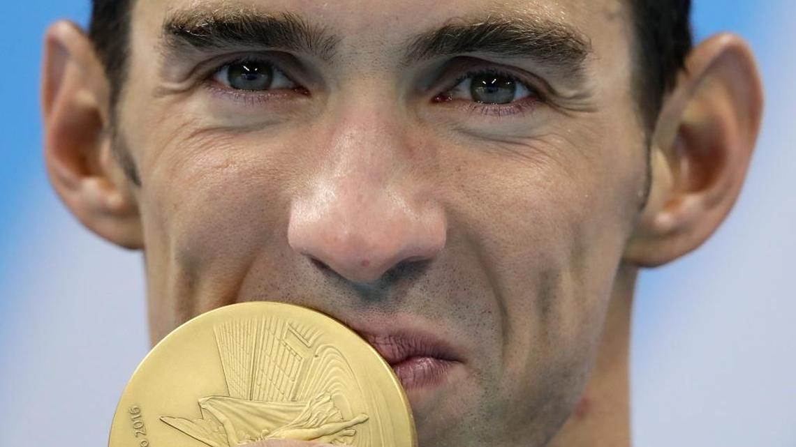 United States' Michael Phelps kisses the gold medal during the medal ceremony for the men's 200-meter individual medley final during the swimming competitions at the 2016 Summer Olympics, Thurs., Aug. 11, 2016, in Rio de Janeiro, Brazil.