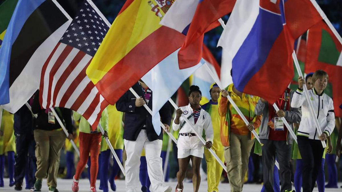Simone Biles carries the flag of the United States during the closing ceremony in the Maracan stadium at the 2016 Summer Olympics in Rio de Janeiro, Brazil, Sunday, Aug. 21, 2016. (AP Photo/Matt Dunham)