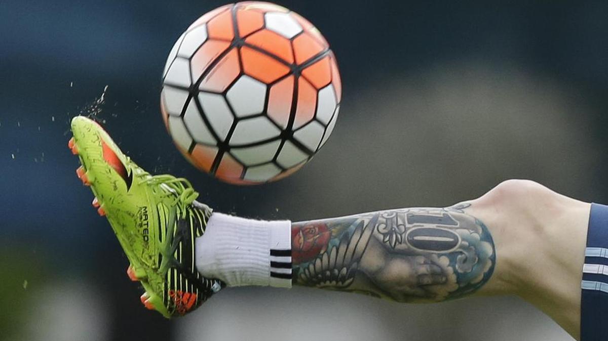 A former UConn soccer player who lost her scholarship after giving the middle finger to a television camera said she is suing the school, calling her punishment excessive.