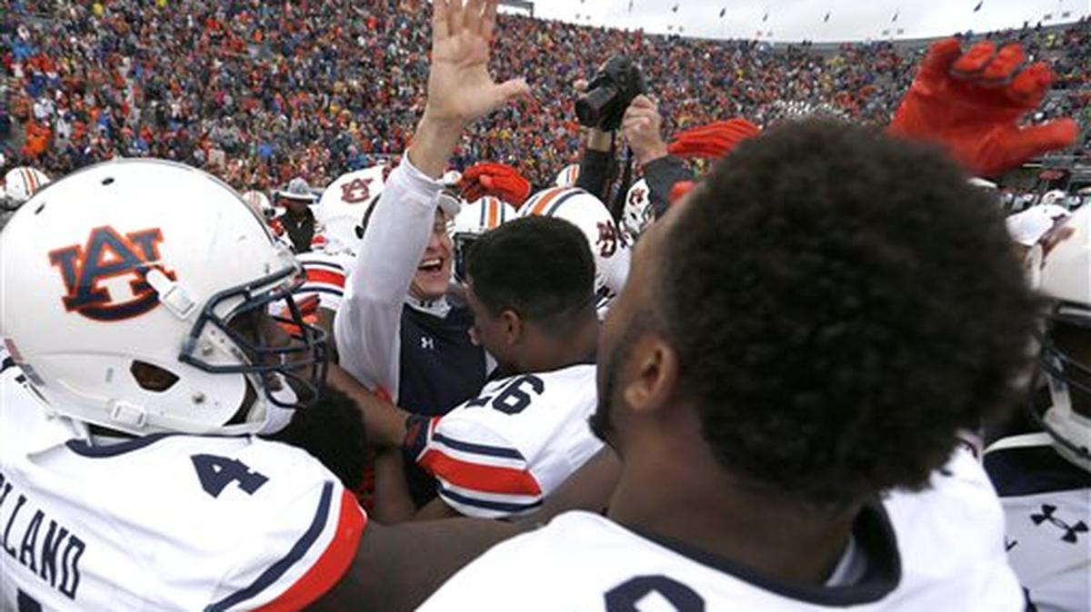 Auburn coach Gus Malzahn, center, celebrates with his players after they defeated Memphis 31-10 in the Birmingham Bowl NCAA college football game, Wednesday, Dec. 30, 2015, in Birmingham, Ala.