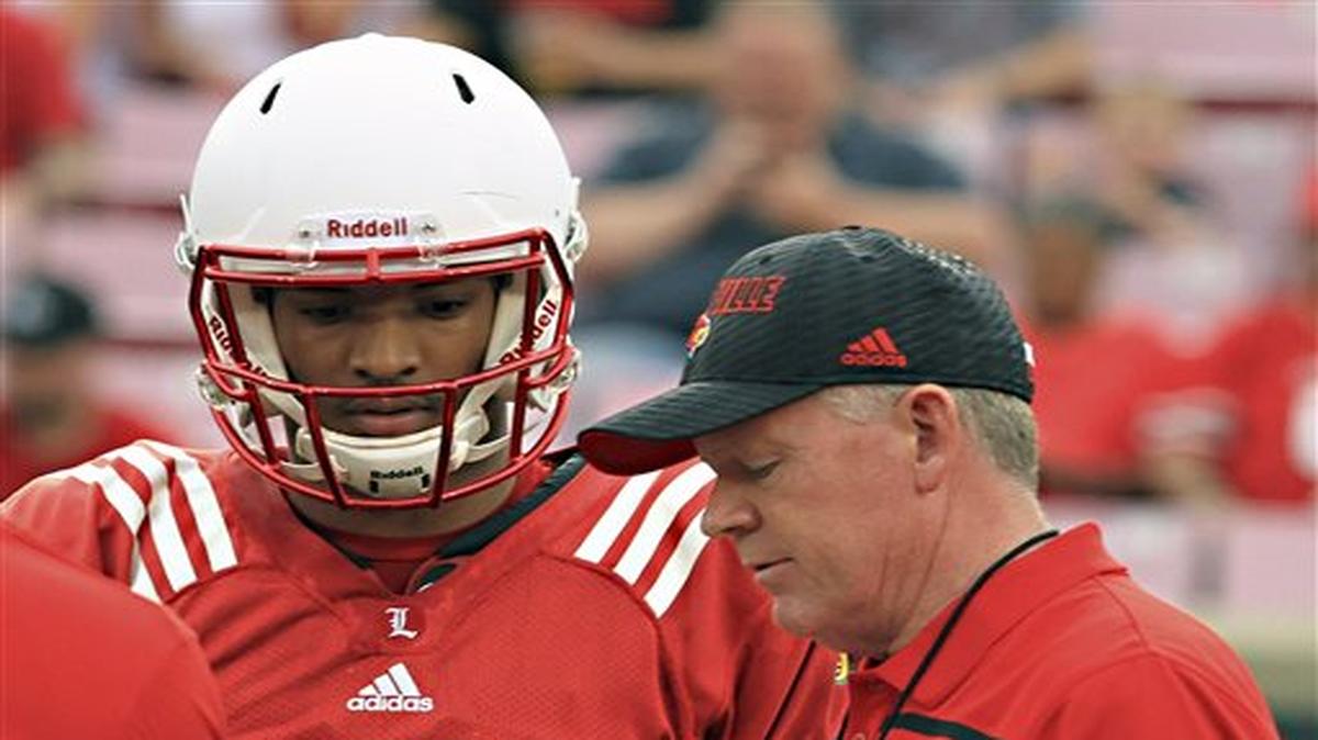 FILE - In this April 17, 2015, file photo, Louisville head football coach Bobby Petrino, right, talks over a play call with quarterback Reggie Bonnafon (7) during the annual spring football scrimmage game at Cardinal Stadium in Louisville, Ky. Having two solid quarterbacks is a good problem to have at first glance, but the task for Louisville coach Bobby Petrino as camp opens in Year 2 is deciding between Reggie Bonnafon and Kyle Bolin and establishing offensive consistency..