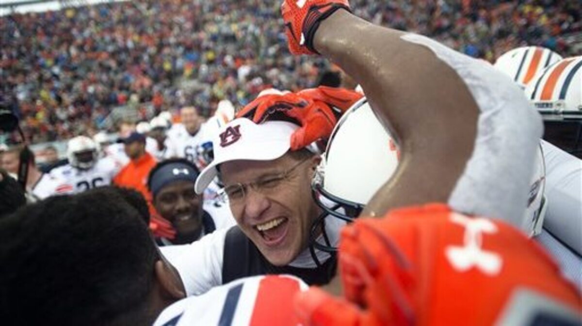 Auburn coach Gus Malzahn, center, celebrates with his players after they defeated Memphis 31-10 in the Birmingham Bowl NCAA college football game, Wednesday, Dec. 30, 2015, in Birmingham, Ala. (Albert Cesare/The Montgomery Advertiser via AP) NO SALES; MANDATORY CREDIT