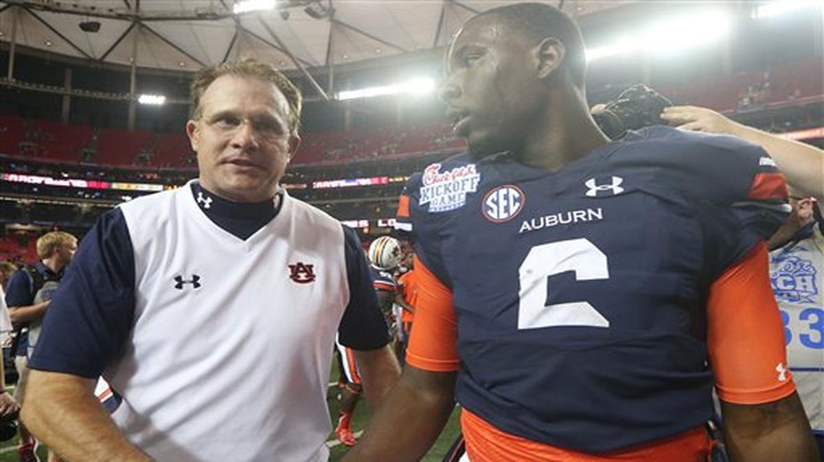 Auburn head coach Gus Malzahn, left, walks off the field with Auburn quarterback Jeremy Johnson (6) after the second half of an NCAA college football game against Louisville, Saturday, Sept. 5, 2015, in Atlanta. Auburn won 31-24.