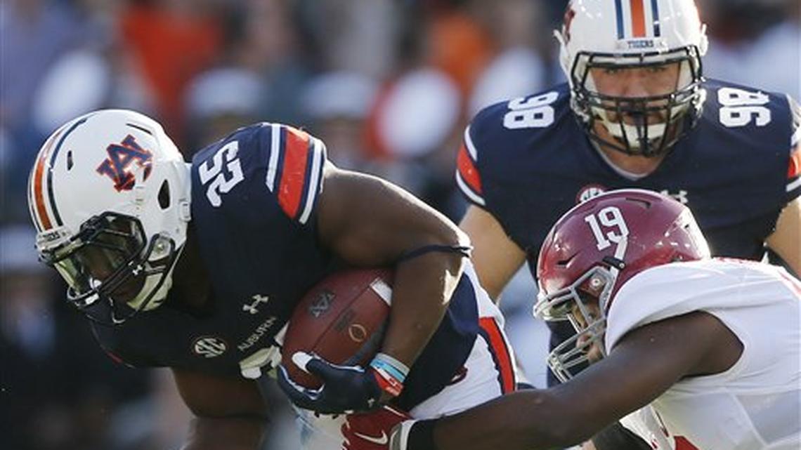 Auburn running back Peyton Barber (25) runs the ball and is tackled by Alabama linebacker Reggie Ragland (19) during an NCAA college football game, Saturday, Nov. 28, 2015, in Auburn, Ala.