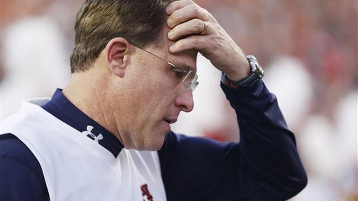 FILE - In this Nov. 28, 2015 file photo, Auburn head coach Gus Malzahn walks off the field with his head down in the first half during an NCAA college football game against Alabama, in Auburn, Ala. Malzahn's tasks leading up to the Birmingham Bowl against Memphis include replacing Will Muschamp as defensive coordinator and secondary coach Travaris Robinson, who went with the new South Carolina head man.
