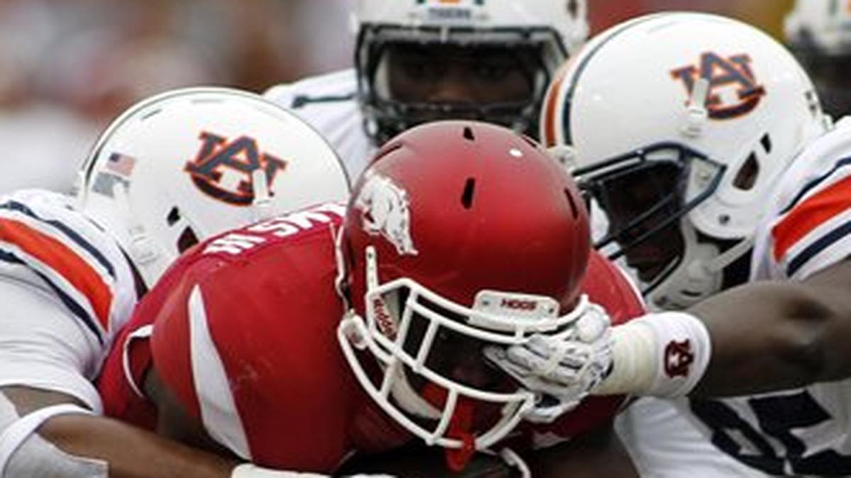 Arkansas' Rawleigh Williams III, center, attempts to break through the grip of the Auburn's defense during an NCAA college football game Saturday, Oct. 24, 2015, in Fayetteville, Ark.