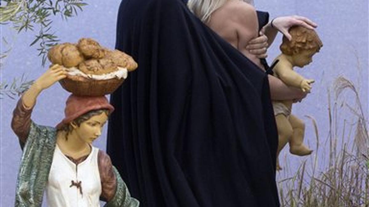 Un policía del Vaticano deteniene a una activista feminista ucraniana semindesnuda tras llevarse una figura del niño Jesús de un nacimiento en la Plaza de San Pedro el jueves 25 de diciembre del 2014.