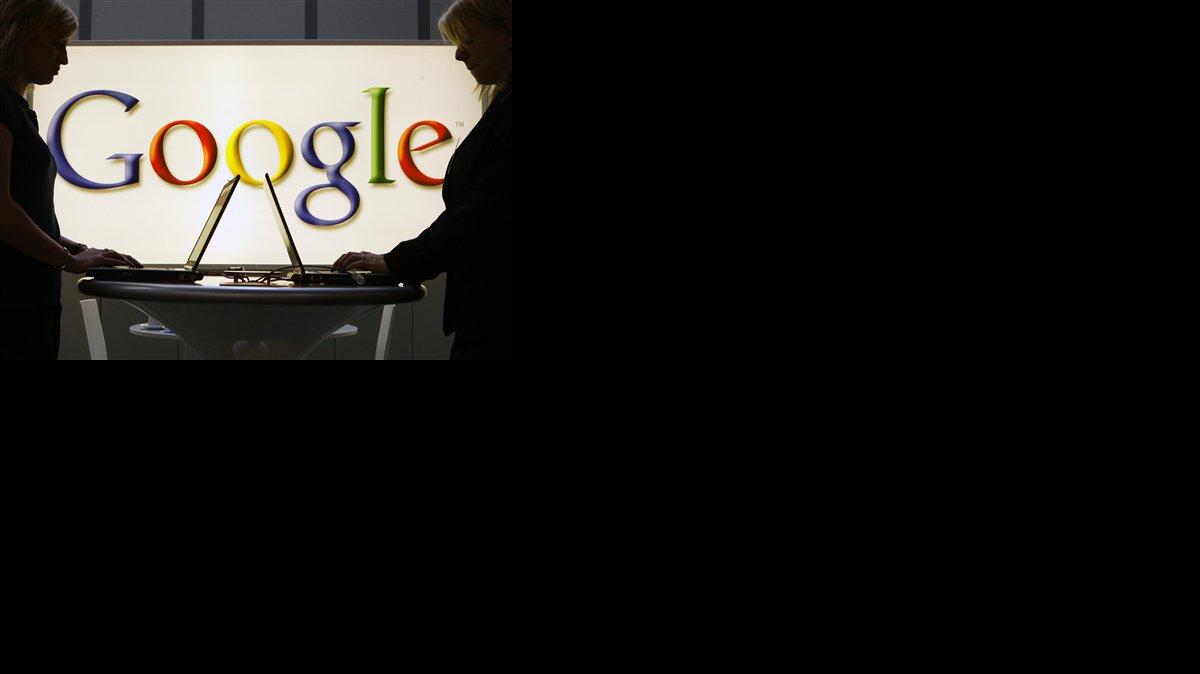 ARCHIVO - En imagen del 17 de abril de 2007, dos expositores trabajan en sus computadoras frente al letrero iluminado del logotipo de Google en la feria industrial de Hanover, Alemania. Cerca de 145.000 peticiones para borrar su historial en Google han sido presentadas en países pertenecientes a la Unión Europea y desde otros fuera del bloque por personas que buscan limpiar su reputación en internet, de acuerdo con cifras de la compañía de Mountain View, California, dadas a conocer el viernes 10 de octubre de 2014.